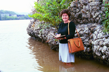 Suzy Meyer taking notes while standing in the river